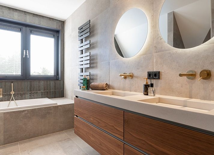 Hoofdingang van vakantiehuis MIEKIE in Buren, Ameland met houten trap en groene omgeving.