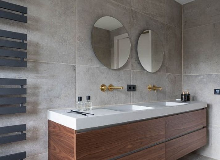 Kind speelt op trampoline bij vakantiehuis MIEKIE in Buren, Ameland, omringd door bomen.