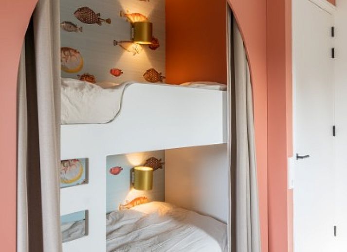 Kind speelt op trampoline bij vakantiehuis MIEKIE in Buren, Ameland, omringd door bomen.