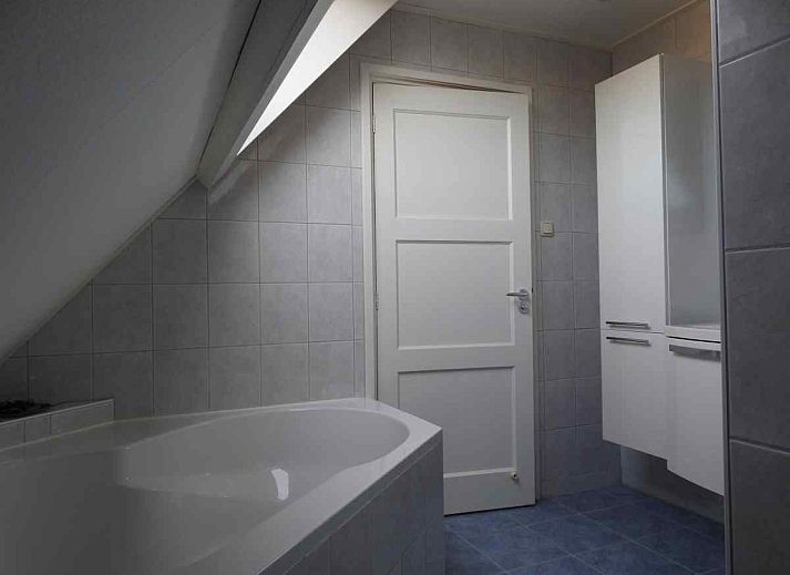 Cozy dining room in vacation home WA003, Buren, Ameland with round table and country style.