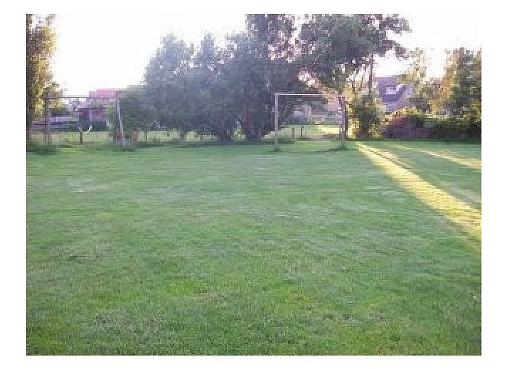 Ferienhaus Pondarosa in Buren, Ameland, mit traditioneller Fassade und gruenem Garten, ideal fuer einen entspannten Aufenthalt auf den Watteninseln.