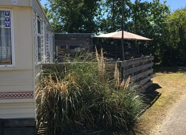 Cozy living room in mobile home De Hout, Buren, Ameland, with spacious sitting area and lots of light.