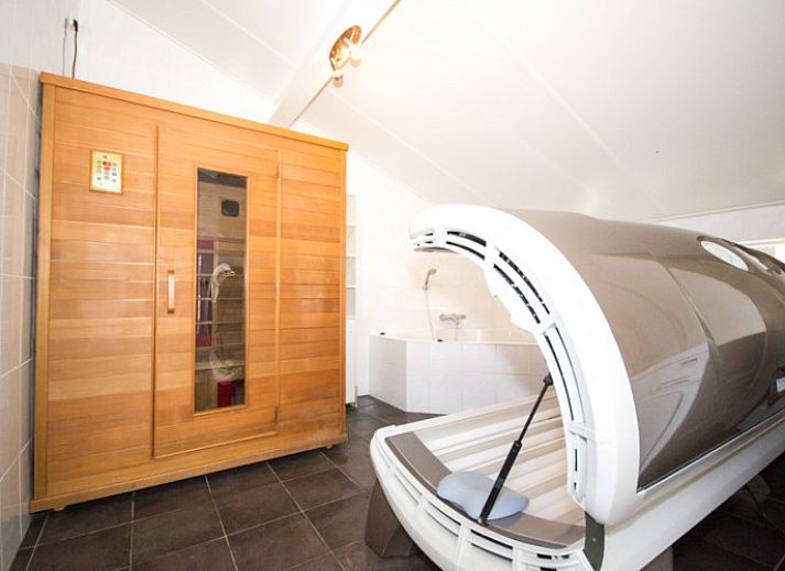 Gemtliches Wohnzimmer von Bungalow 18 in Buren, Ameland, mit bunten Mbeln und Gartenblick.