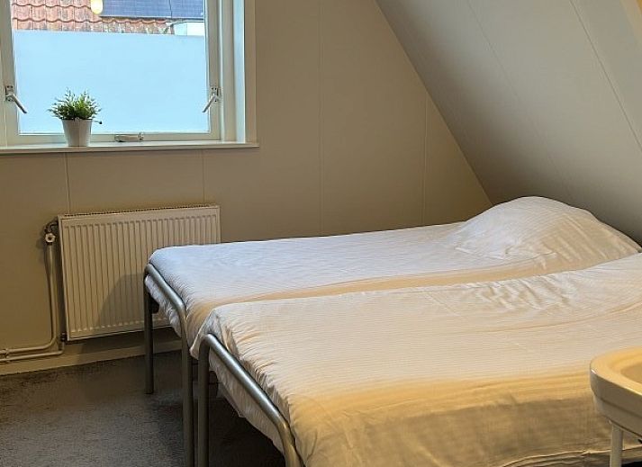 Winterse charme bij vakantiehuis Oerd in Hollum, Ameland met sneeuwbedekte tuin.
