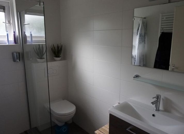 Aussenansicht von DUINVILLA 6, einem Ferienhaus in Hollum auf Ameland, mit Terrasse und gruener Umgebung.