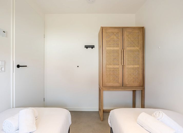 Sfeervolle slaapkamer in Strandlodge 4, een vakantiehuis in Hollum, Ameland, met moderne inrichting en uitzicht op de rustige omgeving.