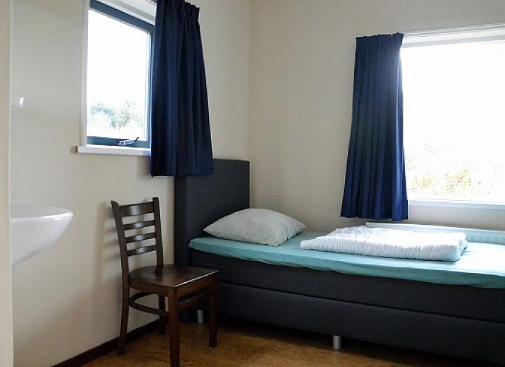 The Woonhuis vacation home in Hollum, Ameland with classic brick facade and green surroundings.