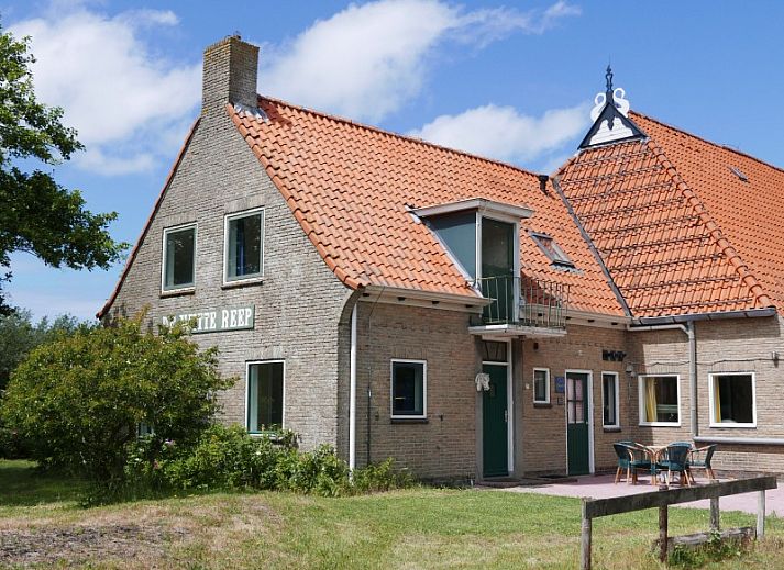 Cozy living room in Het Woonhuis, vacation home in Hollum, Ameland with comfortable sofas and lots of light.