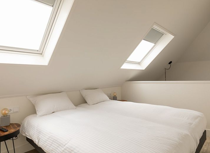 Essecke in der Unterkunft Dorsvloer, Hollum, Ameland, mit Holztisch und Blumenvase fuer eine stimmungsvolle Mahlzeit.