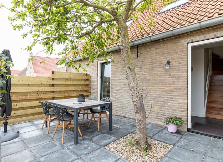 Essecke in der Unterkunft Dorsvloer, Hollum, Ameland, mit Holztisch und Blumenvase fuer eine stimmungsvolle Mahlzeit.