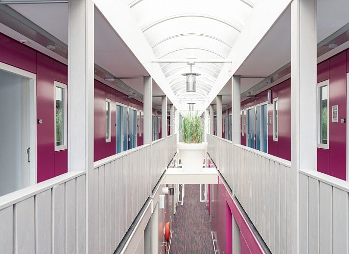 Stilvolles Wohnzimmer mit TV und Buecherregal in Amelander Kaap 126, Hollum, Ameland.