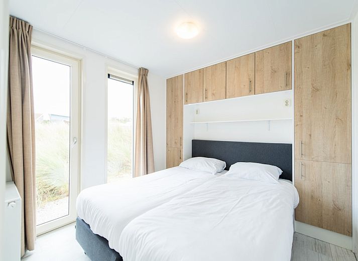 Gemuetliches Wohnzimmer von Waddenlodge 6+2, einem Ferienhaus in Hollum, Ameland. Helle Einrichtung mit bequemen Sitzgelegenheiten und viel natuerlichem Licht.