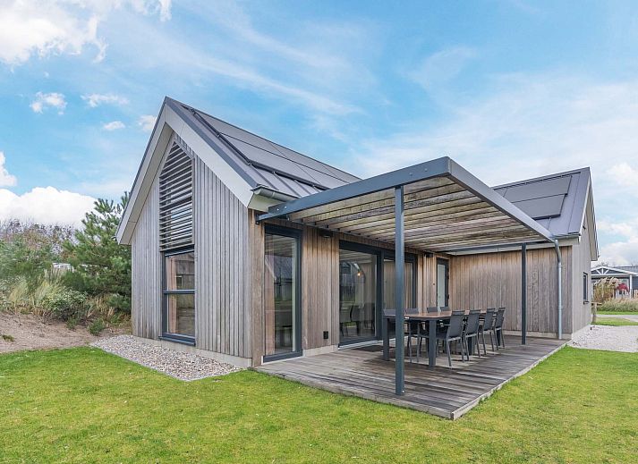 Freistehendes Haus in Hollum, Ameland, mit moderner Holzfassade und sonniger Umgebung.