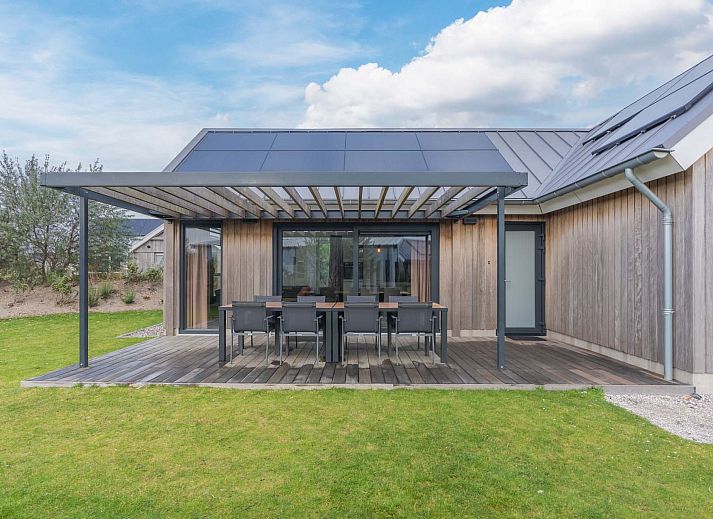 Freistehendes Haus in Hollum, Ameland, mit moderner Holzfassade und sonniger Umgebung.