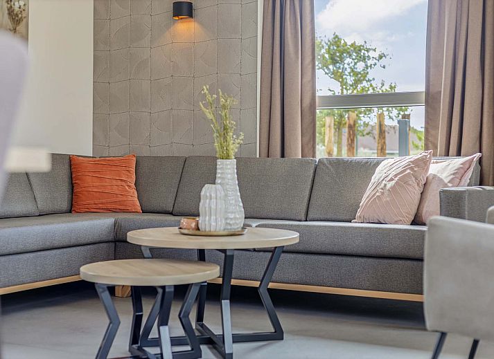 Gerumige Terrasse des Ferienhauses in Hollum, Ameland, mit berdachung und Gartenmbeln.