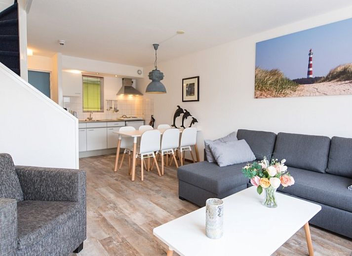 Gezellige woonkamer in appartement Zilverschoon, Hollum, Ameland met comfortabele zitruimte en uitzicht op terras.