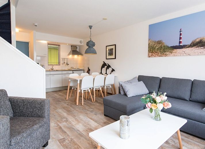 Gezellige woonkamer in appartement Zilverschoon, Hollum, Ameland met comfortabele zitruimte en uitzicht op terras.