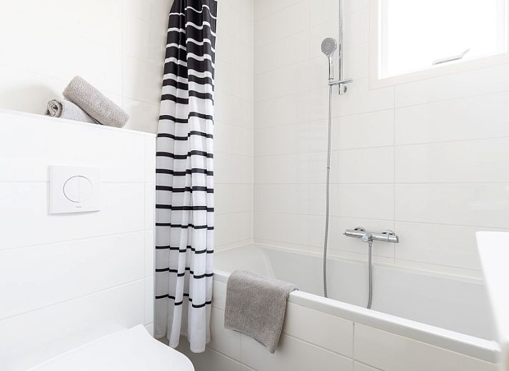 Stylish sitting area in Bornrif, Hollum, Ameland with comfortable sofa and colorful rug.