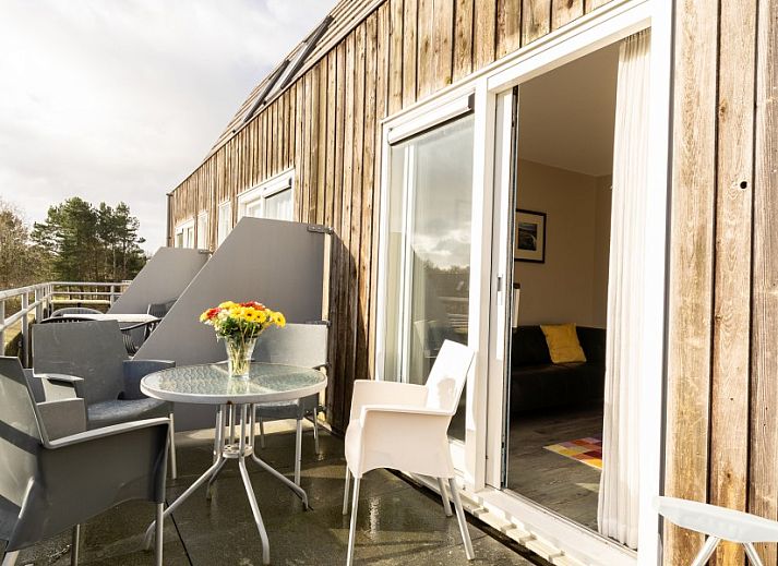 Stylish sitting area in Bornrif, Hollum, Ameland with comfortable sofa and colorful rug.