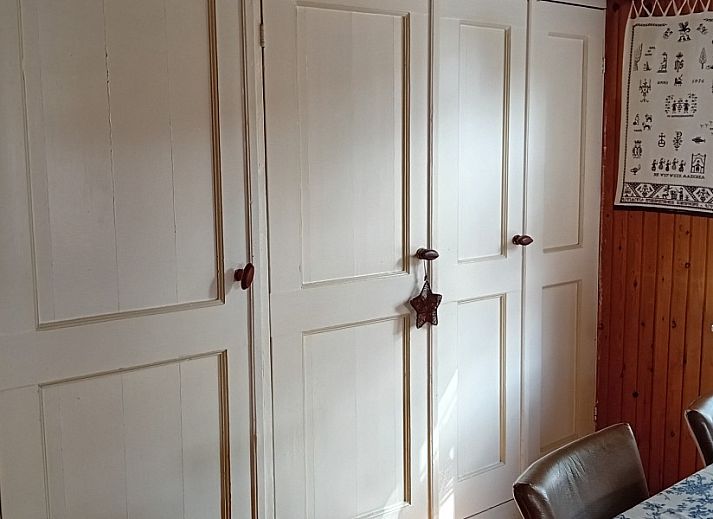 Gemuetliches Wohnzimmer im Ferienhaus Anno 1618, Hollum, Ameland mit Holzeinrichtung und bequemen Sitzgelegenheiten.