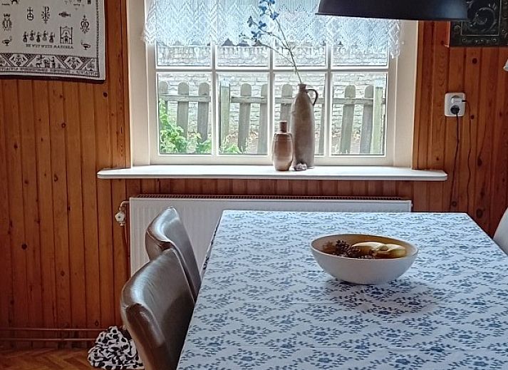 Gemuetliches Wohnzimmer im Ferienhaus Anno 1618, Hollum, Ameland mit Holzeinrichtung und bequemen Sitzgelegenheiten.