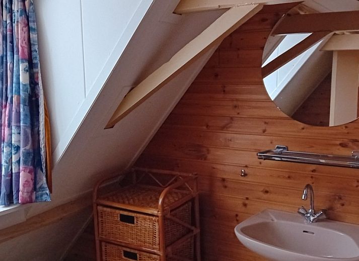 Gemuetliches Wohnzimmer im Ferienhaus Anno 1618, Hollum, Ameland mit Holzeinrichtung und bequemen Sitzgelegenheiten.