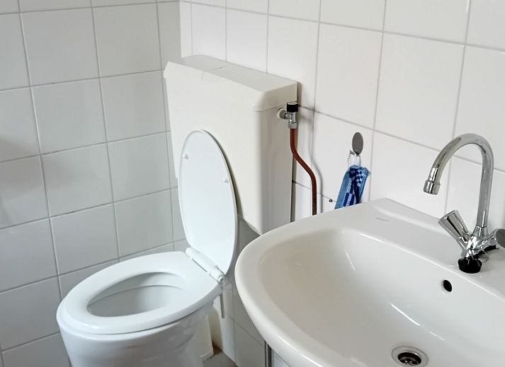 Gemuetliche Ecke im Ferienhaus Anno 1618, Hollum, Ameland mit Fernseher und antikem Ofen.