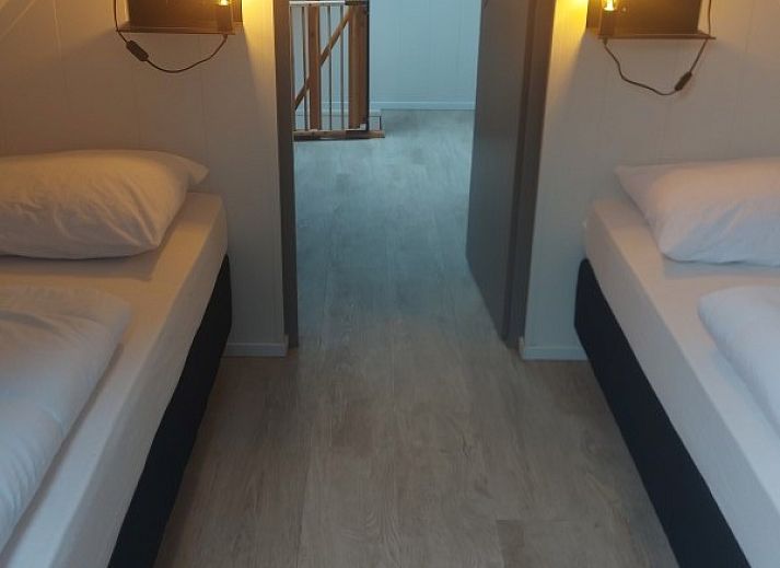 Moderner Essbereich im Ferienhaus Zeester, Hollum, Ameland. Stilvoller Holztisch und gruene Wandakzente.