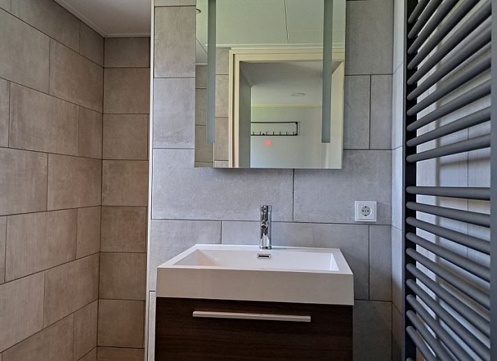 Moderner Essbereich im Ferienhaus Zeester, Hollum, Ameland. Stilvoller Holztisch und gruene Wandakzente.