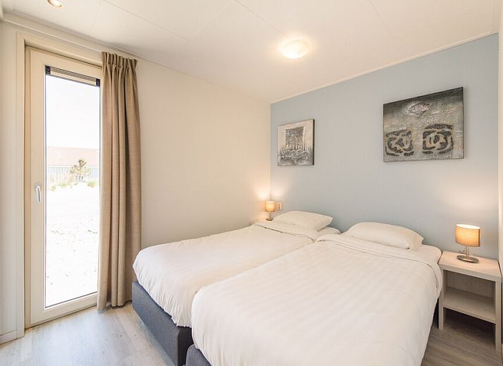 Gemuetliches Wohnzimmer der Waddenlodge 6 in Hollum, Ameland, mit viel Licht und bequemen Sitzgelegenheiten fuer einen entspannten Urlaub.