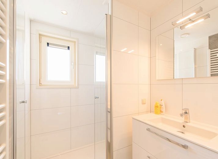 Gemuetliches Wohnzimmer der Waddenlodge 6 in Hollum, Ameland, mit viel Licht und bequemen Sitzgelegenheiten fuer einen entspannten Urlaub.