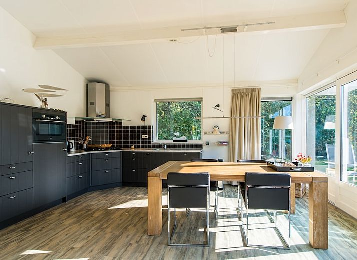 Geniet van de serene veranda van Vijverwoning 4, een charmante bungalow in Hollum, Ameland, omgeven door de natuur van de Waddeneilanden.