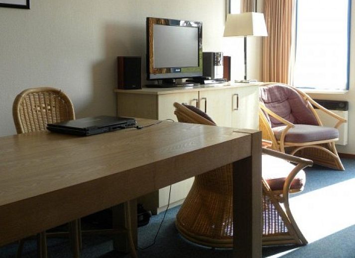 Gemtliches Wohnzimmer in Amelander Kaap Nr. 54, Hollum, Ameland mit rotem Sofa und moderner Einrichtung.