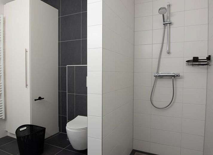 Moderne Kueche im Ferienhaus in Nes, Ameland, mit Essbereich und viel Licht.