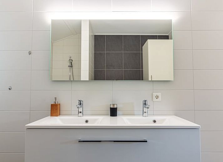 Moderne Kueche im Ferienhaus in Nes, Ameland, mit Essbereich und viel Licht.