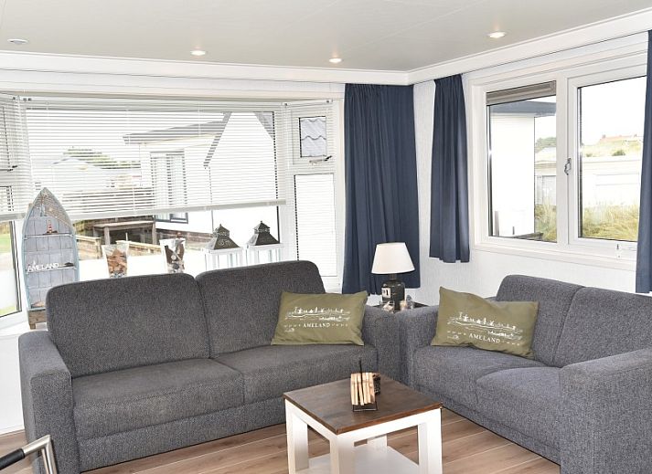 Gezellige woonkamer in Chalet Zeester, stacaravan Buren Ameland met comfortabele banken en moderne inrichting.