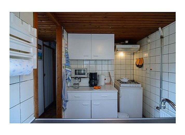 Charmantes Ferienhaus Schier in Schiermonnikoog, Watteninseln, umgeben von grnen Hecken.