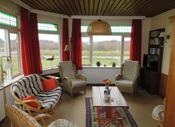 Zeerust-Ferienhaus in Schiermonnikoog mit Blick auf den Leuchtturm und die gruene Umgebung.