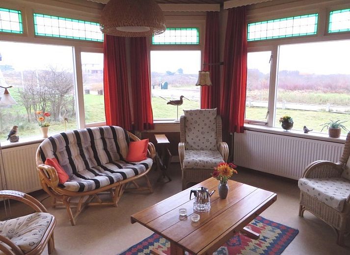 Zeerust-Ferienhaus in Schiermonnikoog mit Blick auf den Leuchtturm und die gruene Umgebung.