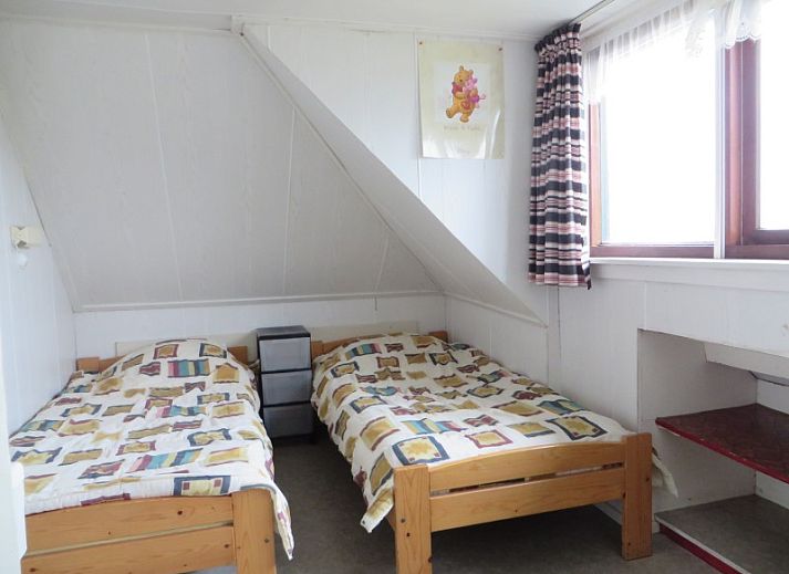 Gemuetliches Wohnzimmer des Ferienhauses Zeerust auf Schiermonnikoog mit bequemen Stuehlen und Blick auf die Natur.