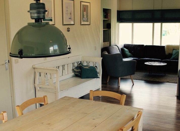 Gezellige keuken in Noenie vakantiehuis op Schiermonnikoog met houten eettafel en moderne apparatuur.