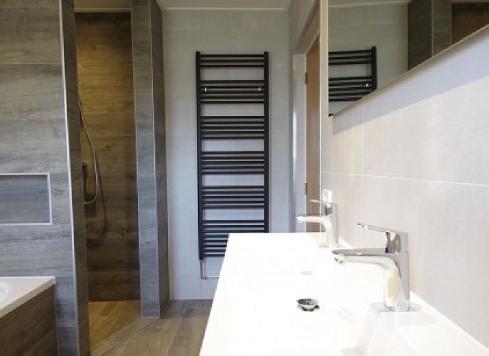 Gezellige keuken in Noenie vakantiehuis op Schiermonnikoog met houten eettafel en moderne apparatuur.