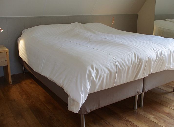 Comfortabele zithoek in Noenie vakantiehuis op Schiermonnikoog met leren bank en sfeervolle verlichting.