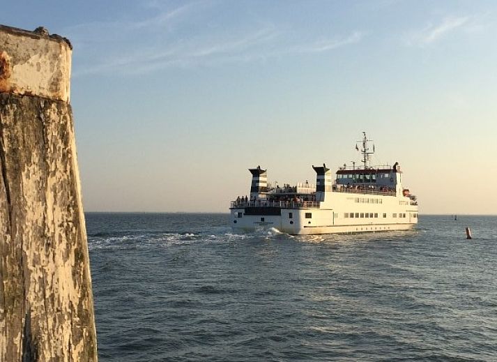Comfortabele zithoek in Noenie vakantiehuis op Schiermonnikoog met leren bank en sfeervolle verlichting.