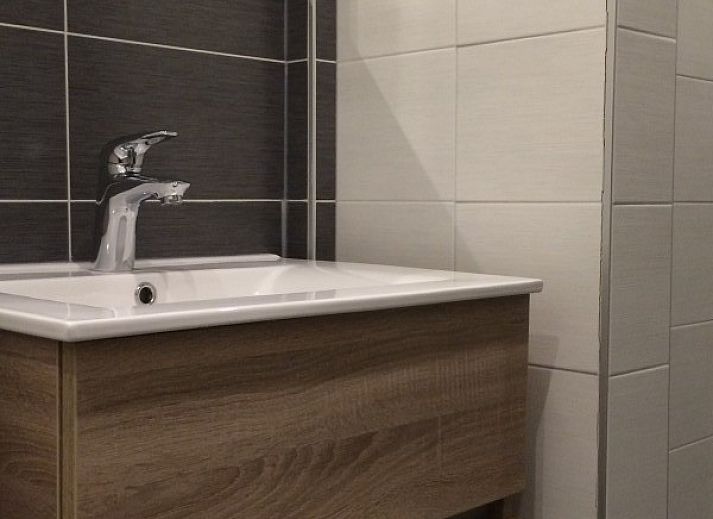 Stylish living room of Louwtjesduin Oost vacation home in Schiermonnikoog overlooking the green garden, Wadden Islands.