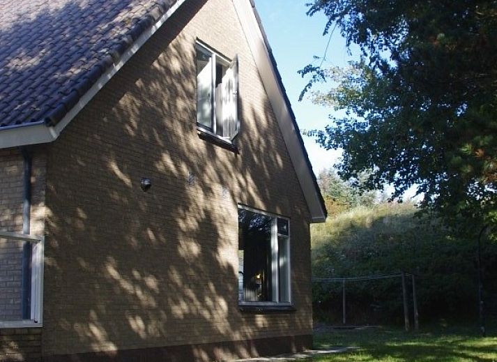 Stylish living room of Louwtjesduin Oost vacation home in Schiermonnikoog overlooking the green garden, Wadden Islands.
