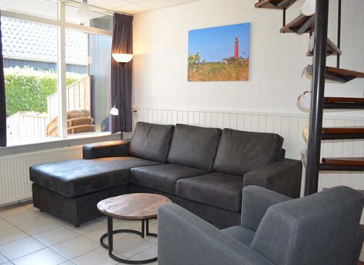 Geraeumiges Schlafzimmer in Boersma's Apartments auf Schiermonnikoog, mit Blick auf den Garten und gemuetlicher Sitzecke.