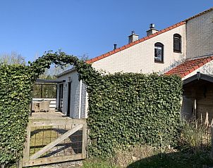 La Guitarra in De Cocksdorp Texel, vakantiehuis met groene omheining en toegangshek.