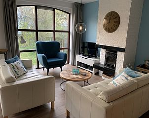 Gezellige woonkamer van La Guitarra vakantiehuis in De Cocksdorp Texel met open haard.