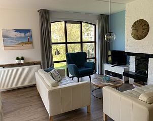 Comfortabele zithoek in La Guitarra vakantiehuis in De Cocksdorp Texel met uitzicht op tuin.